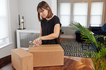 Woman opening a shipment received by mail with scissors