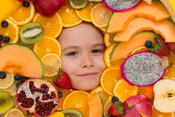 Fototapeta na wymiar Funny fruits. Kid smiling face portrait surrounded by fruits. Kids face are peeking out of the mix fruits.