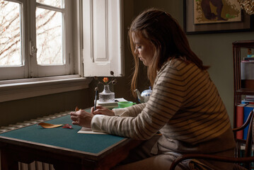 Woman sketching at the desk with tea