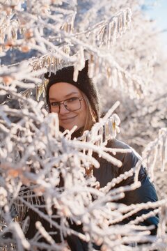 Smiling  woman posing with trees in snow 