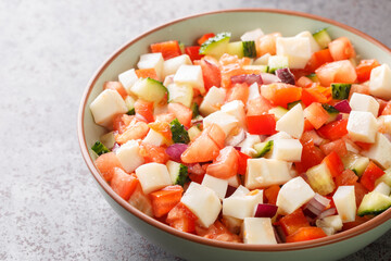 Bahamian conch salad is a vibrant and crunchy salad made using raw pound conch meat and vegetables closeup on the plate on the table. Horizontal