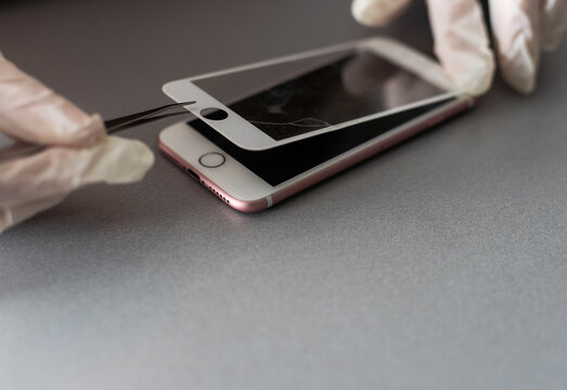 Kiev, Ukraine - December 10, 2022: Close-up iPhone repair, replacement of protective glass