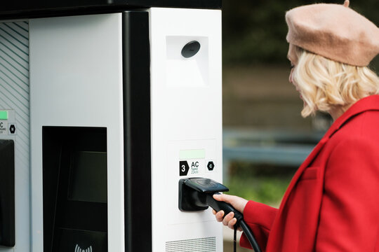 Anonymous woman using Electric Car Charge Station