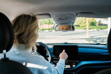 Anonymous woman using GPS Navigator In Car