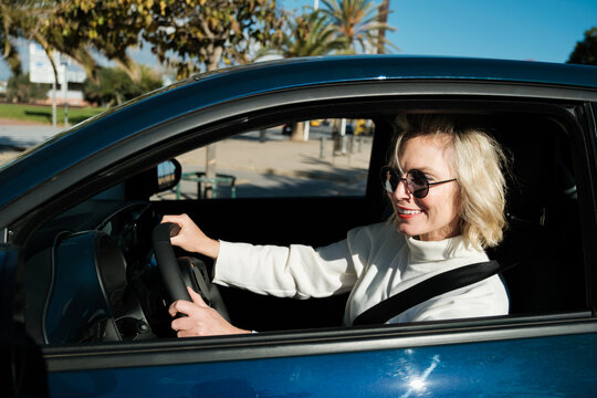 Cheerful woman driving a car 