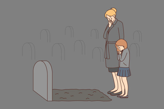Depressed woman and child crying at tombstone 