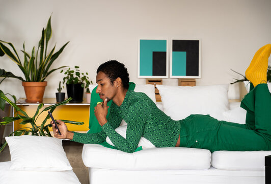 Man relaxing at home using phone