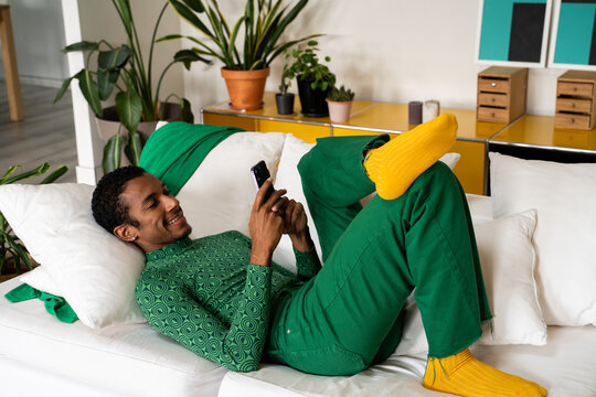 Man relaxing at home using phone