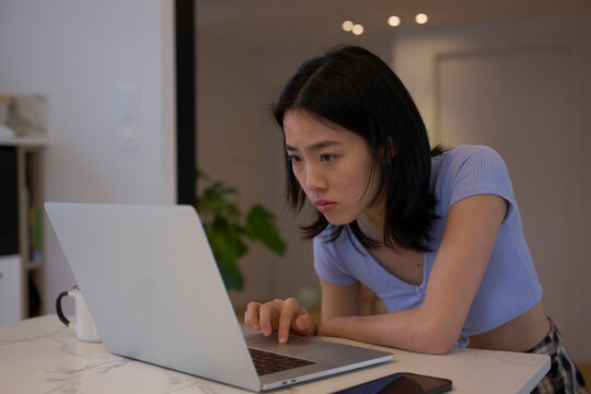 Freelancer reading report on laptop.