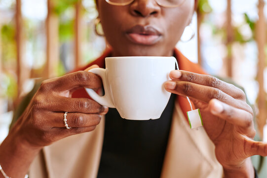 Woman blowing on a hot cup of tea