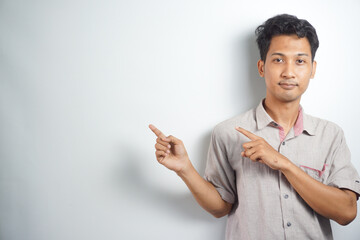 Young handsome man over isolated background pointing to the side to present a product