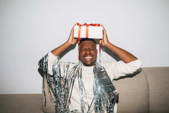 Man Holding Christmas Present and Laughing 