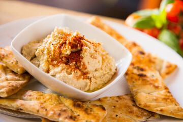 Hummus is a cream of chickpeas cooked with lemon juice, which includes tahini paste and olive oil, which, depending on the local variant, can also include other ingredients such as garlic or paprika.