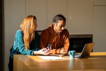 Serious couple paying utility bills at home
