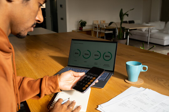 man  counting expenses on calculator at home