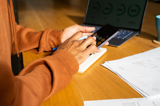 Man paying utility bills from home calculating expenses