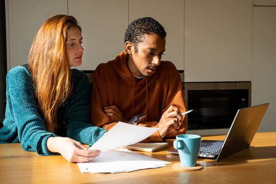 Serious friends paying utility bills at home