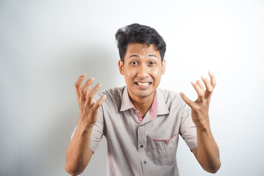Handsome asian man annoyed angry in furious gesture on white background