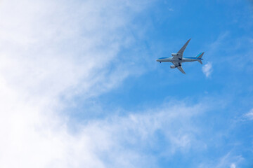 Fototapeta na wymiar View of airplane flying in blue sky among white clouds. . High quality photo