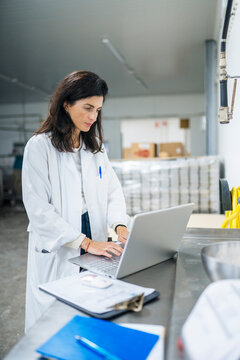 Supervisor with laptop in factory workshop