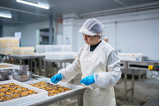 Hispanic woman working in workshop of canning factory