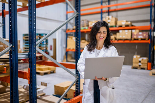 Optimistic warehouse worker using netbook