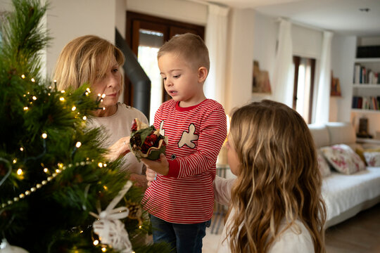 Grandma and grandchildren sitting in front of Christmas tree
