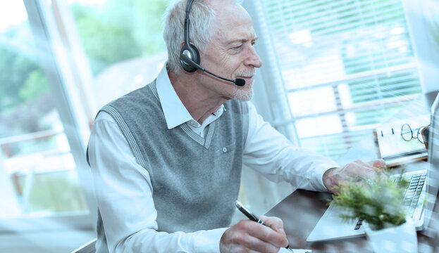 Businessman talking on a headset and using a laptop; light effect - Powered by Adobe