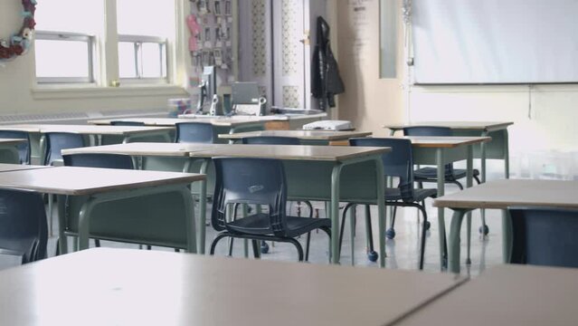 Establishing shot of empty classroom in school with desks