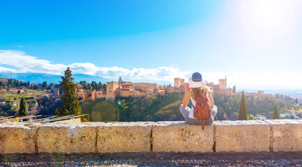 tourism at Granada,Woman tourist looking at Ancient arabic fortress Alhambra - obrazy, fototapety, plakaty