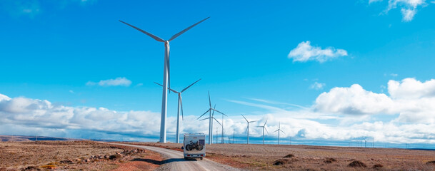 Motorhome on the road with wind turbines