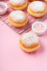 Donuts Doughnuts with Icing Sugar and Sprinkles on Pink Background