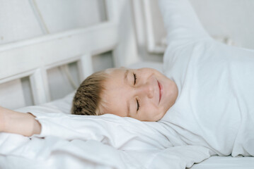 Fototapeta na wymiar Мальчик спит в кровати . белая постель