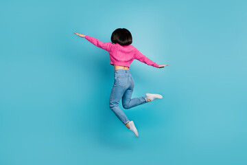 Obraz premium Full length photo of cute cheerful lady wear pink pullover jumping high hands arms wings isolated blue color background