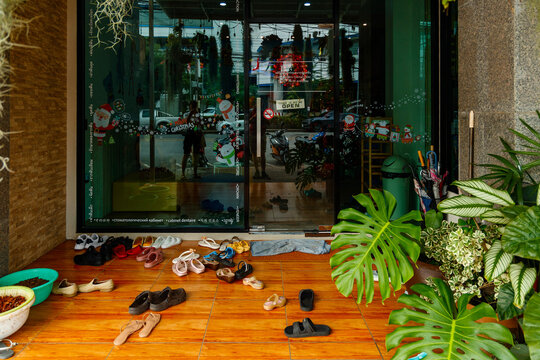 Phuket Town, Thailand - January 15, 2023: Various Shoe Brands Are Scattered In Front Of The Massage Parlor Entrance. The Concept Of Taking Off Shoes Before Entering The House.