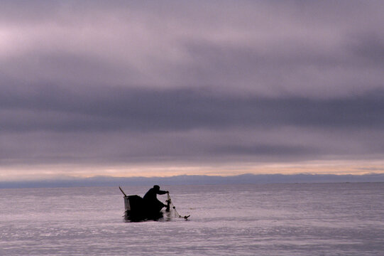 A man in a boat in the Bering Strait, Wales, Alaska, USA.