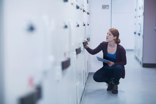 Young female engineer updating control panel using digital tablet in an industrial plant, Freiburg im Breisgau, Baden-Württemberg, Germany