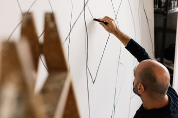 an artist sketches a design on a canvas