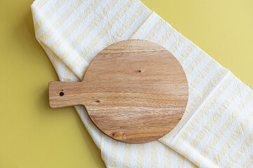 Small wooden cutting board placed on a yellow background