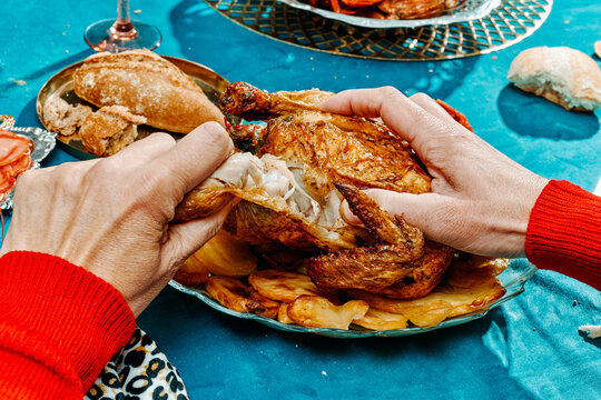 man rips off the leg of a roast turkey