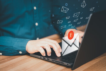 Man hand using a computer laptop and sending online message with email icon in the office. Concept...