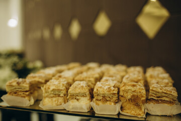Wedding decorations. Reception. Buffet. Fruits and cheese on plates with bread in boxes. Food bar decorated by flowers and lanters
