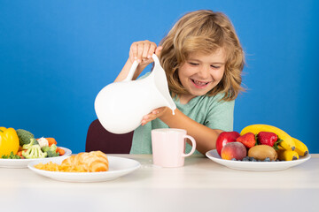 Kid boy pouring whole cows milk. Portrait of child eat fresh healthy food in kitchen at home. Kid boy eating breakfast before school. Child drink dairy milk. Kid boy pouring milk, studio isolated