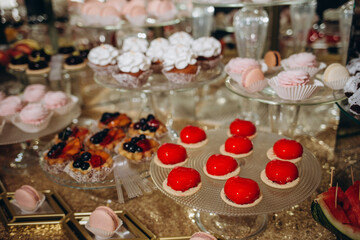 Wedding decorations. Reception. Buffet. Fruits and cheese on plates with bread in boxes. Food bar decorated by flowers and lanters