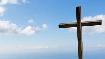 Jesus Christ cross. Easter, resurrection concept. Christian wooden cross on a background with dramatic lighting, colorful mountain sunset, dark clouds and sky, sunbeams.