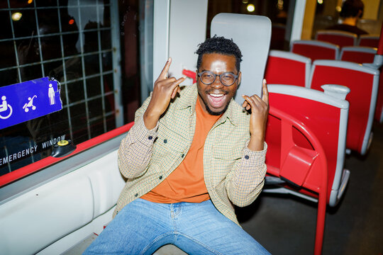 Young man posing happily for camera while riding bus
