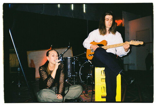 Man plays guitar and woman sings
