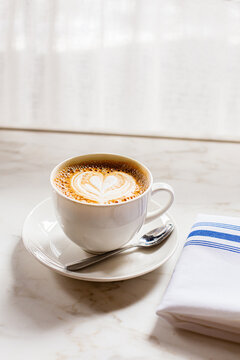 Latte in Teacup Near Cafe Window