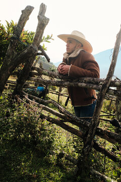 Cowboy resting on wooden corral