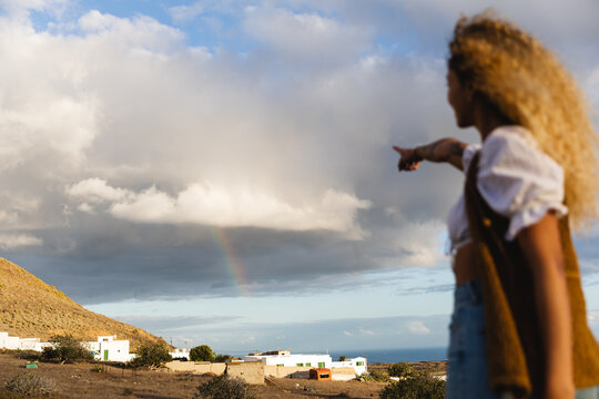 Woman pointing to the rainbow